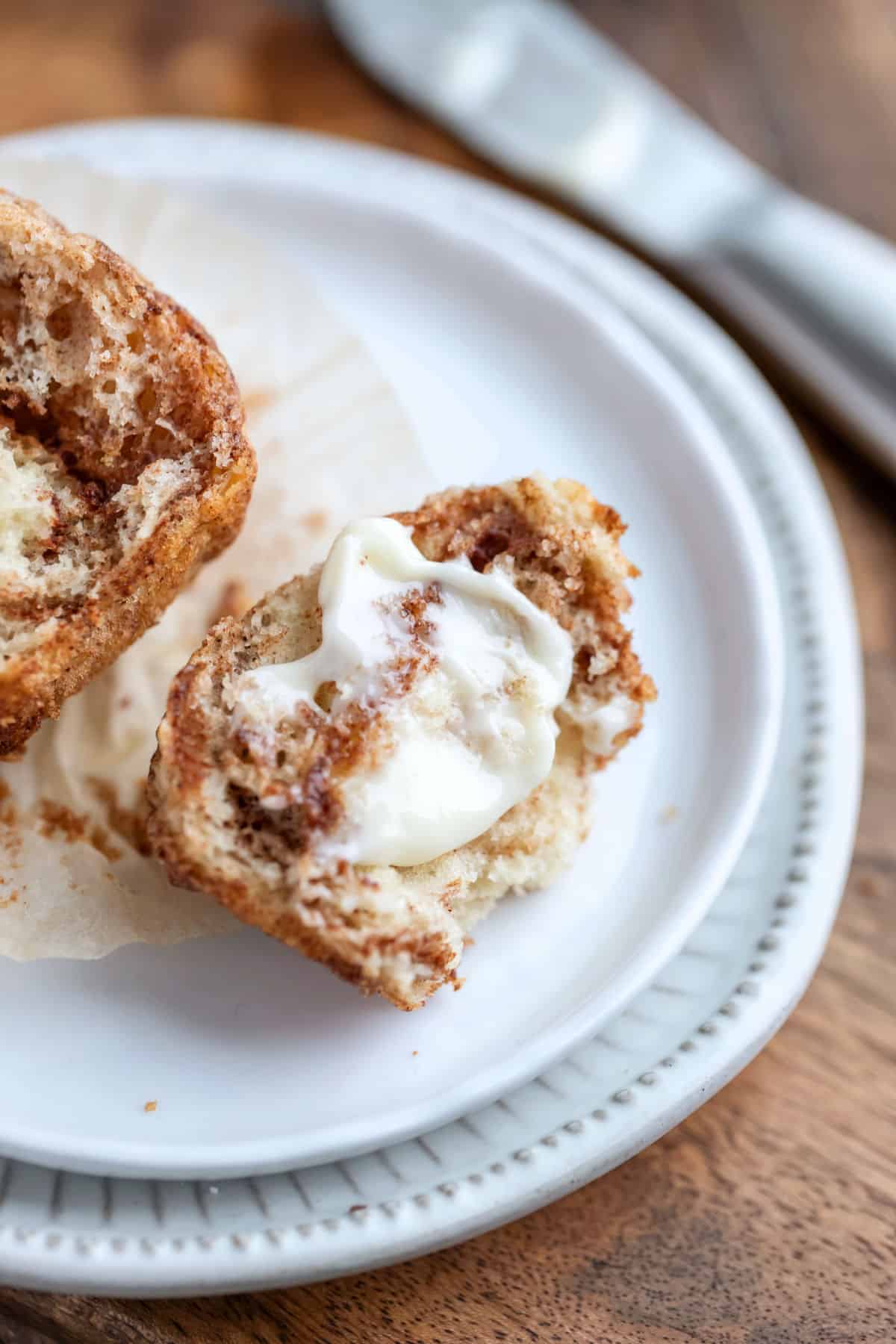 Buttered cinnamon muffin on a white plate.