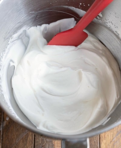 Whipped cream in a silver mixing bowl