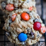 Monster cookies on a black metal cooling rack
