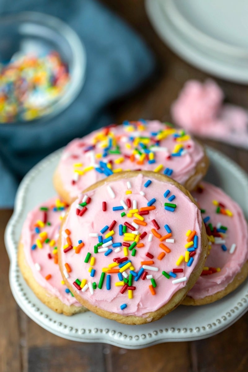 Frosting and sprinkles next to a plate of Lofthouse cookies