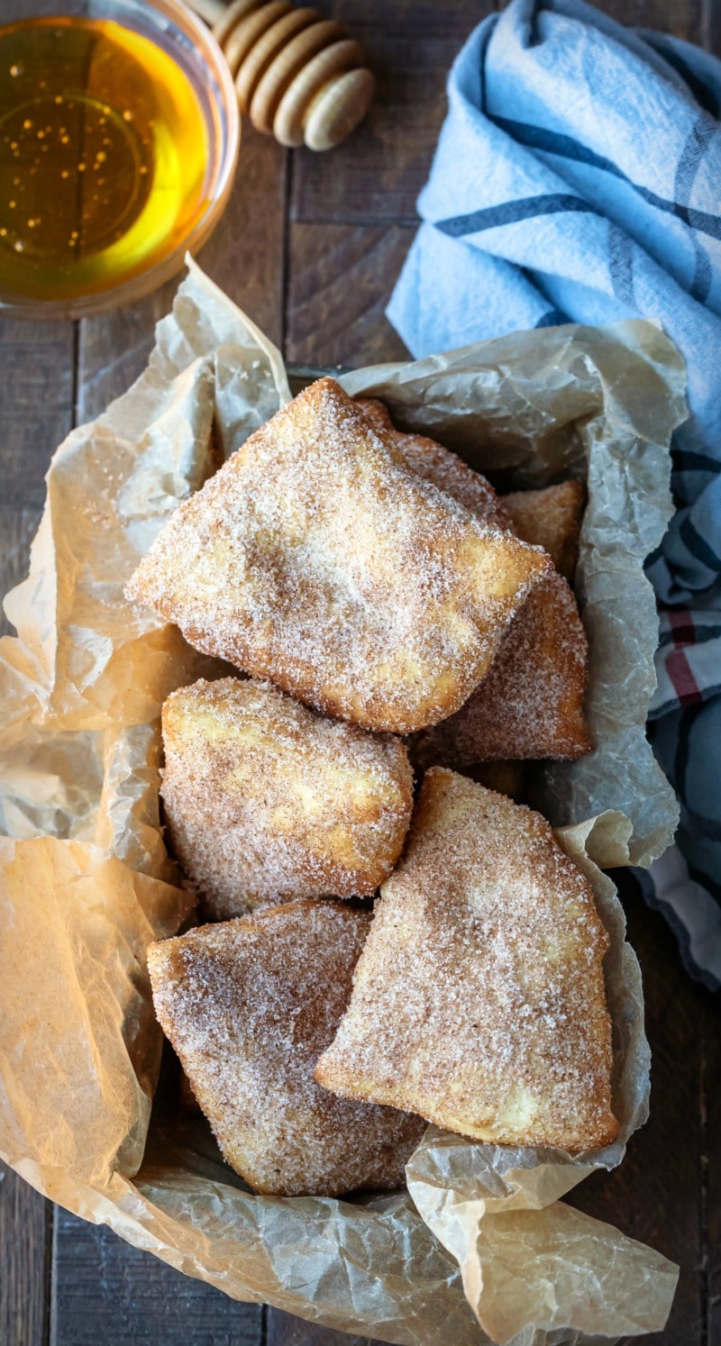 Dish of honey next to stack of sopaipillas