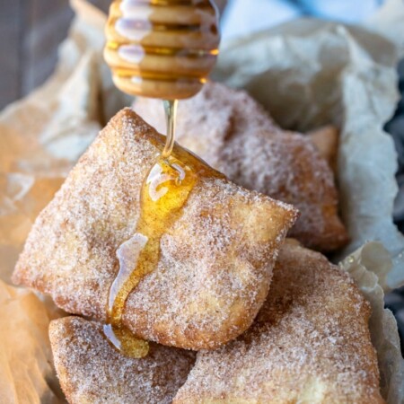 Honey dripping onto pile of sopaipillas