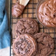 Three chocolate frosted cookies on a wire cooling rack