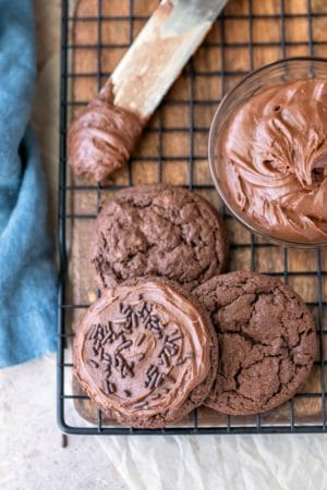 Three chocolate frosted cookies on a wire cooling rack