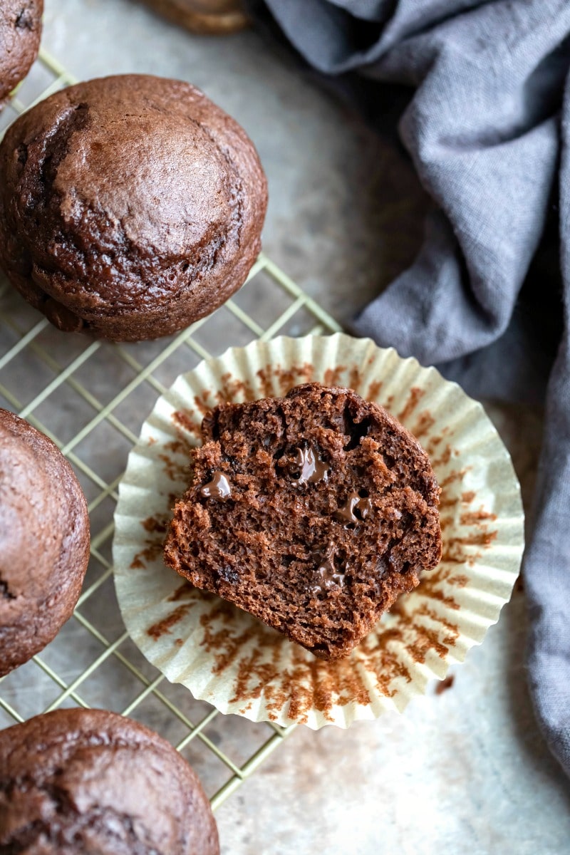 Half of a chocolate chocolate chip muffin on a muffin liner