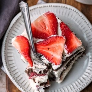 Slice of strawberry icebox cake on a cream plate