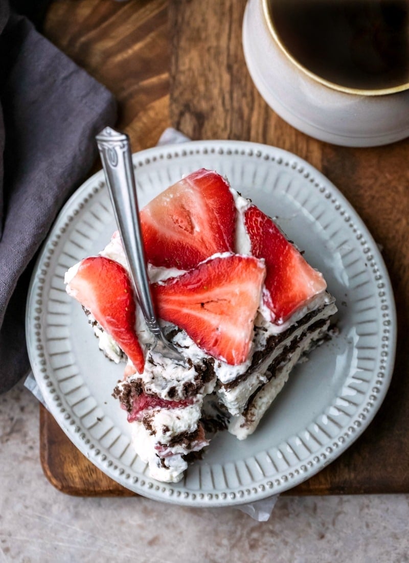 Slice of strawberry icebox cake with a fork taking a bite out of it