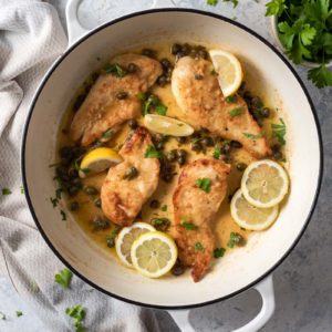Chicken piccata topped with capers and lemon slices