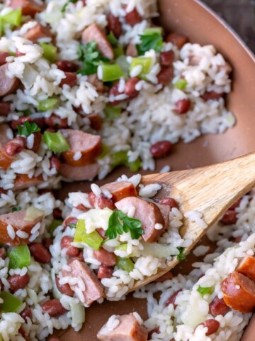 Red beans and rice in a skillet wiht a wooden spoon in it