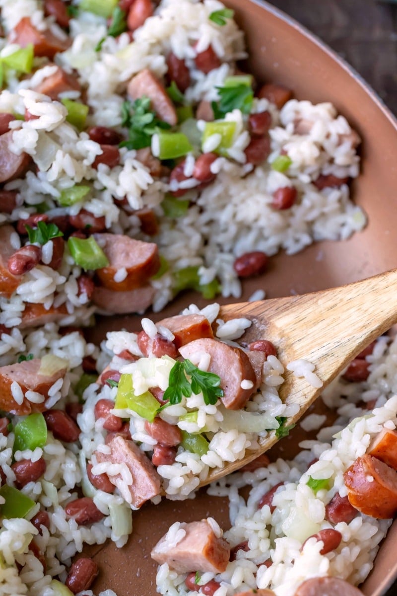 Red beans and rice in a skillet wiht a wooden spoon in it