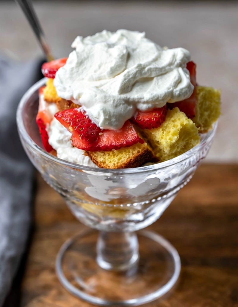 Cubes of sponge cake topped with strawberries and whipped cream