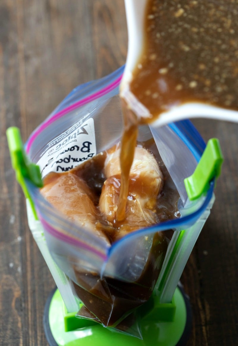 A bowl pouring brown sugar bourbon chicken marinade into a resealable bag