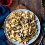 Blue plate with Instant Pot Beef Stroganoff next to two black forks