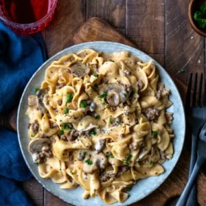 Blue plate with Instant Pot Beef Stroganoff next to two black forks