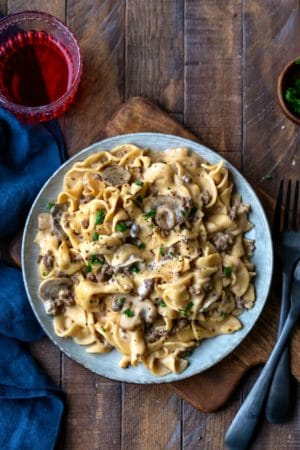 Blue plate with Instant Pot Beef Stroganoff next to two black forks