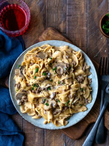 Blue plate with Instant Pot Beef Stroganoff next to two black forks