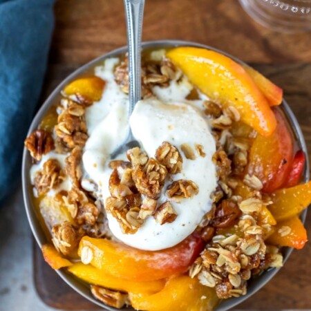 Dish of peach crisp topped with vanilla ice cream