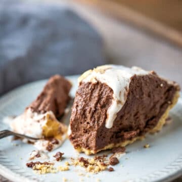 Slice of s'mores pie with a bite next to it on a fork.