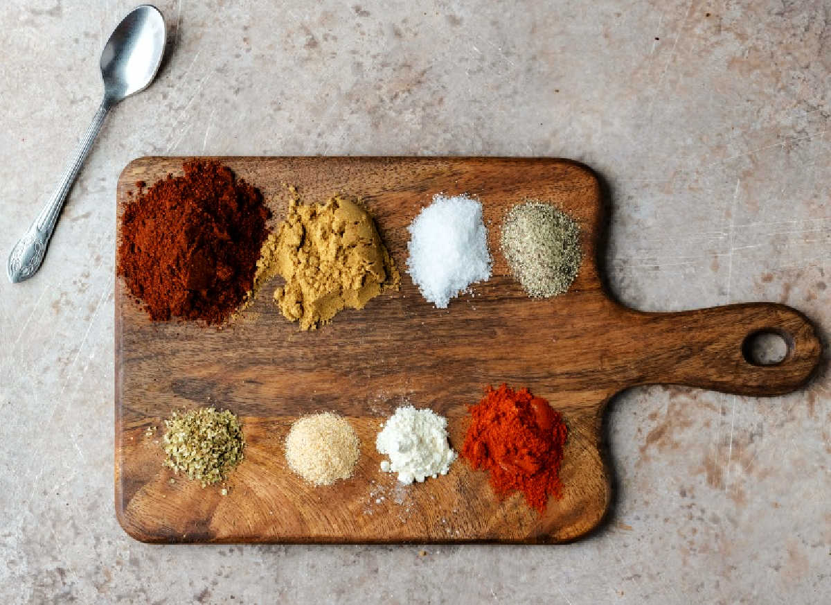 spices for taco seasoning on a wooden cutting board. 
