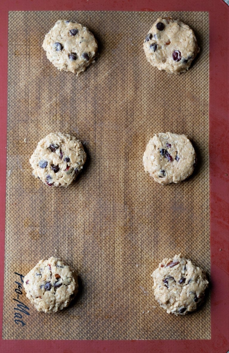 Scoops of breakfast cookie dough on a silicone baking mat
