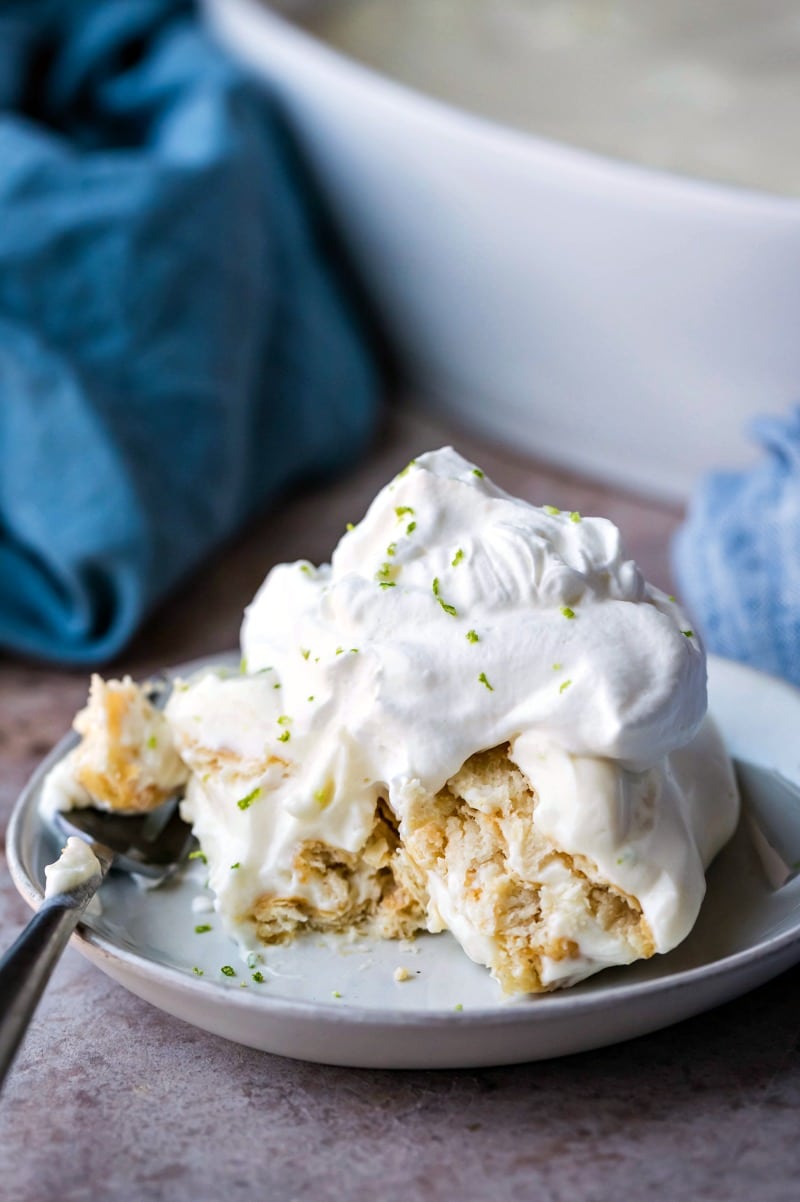 Piece of no bake key lime pie topped with whipped cream and lime zest