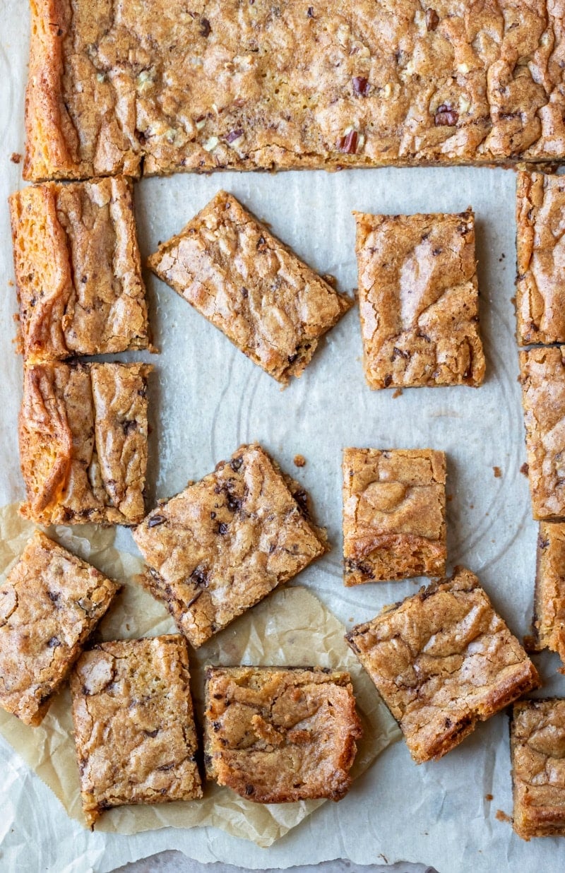 Partially cut tray of blondies on parchment paper