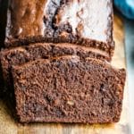 Two slices of chocolate banana bread leaning against the loaf.
