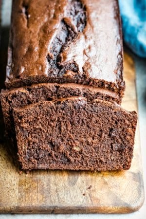 Two slices of chocolate banana bread leaning against the loaf.