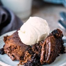 Slow cooker brownies topped with a scoop of vanilla ice cream