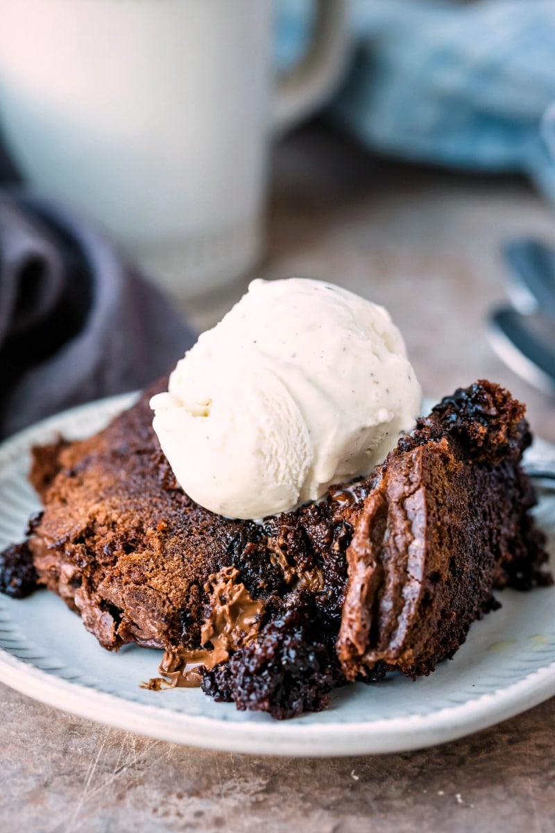 Slow cooker brownies topped with a scoop of vanilla ice cream