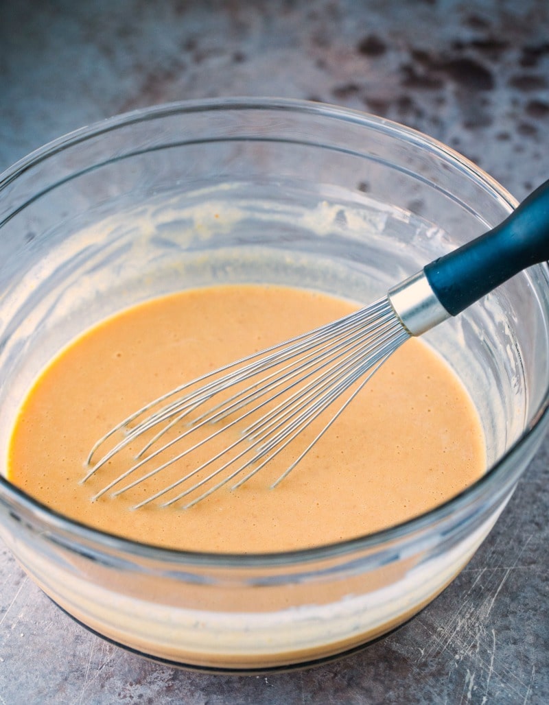 Pumpkin pancake batter in a glass mixing bowl