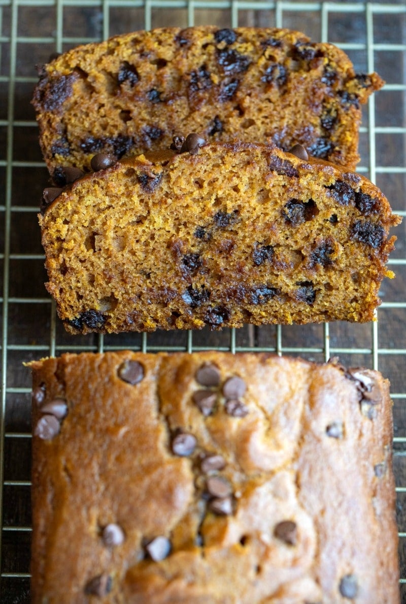 Two slices of pumpkin chocolate chip bread on a wire rack