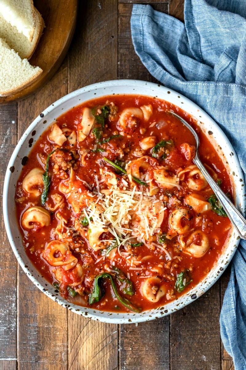 Speckled pottery bowl full of slow cooker tortellini soup