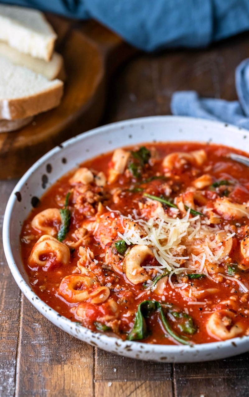 Slow cooker tortellini soup topped with grated parmesan cheese