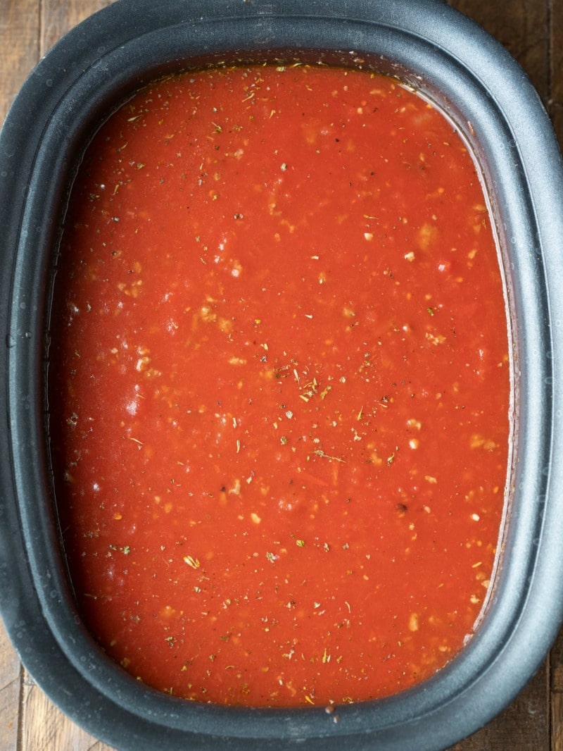 Slow cooker tortellini soup ingredients in a crock pot insert
