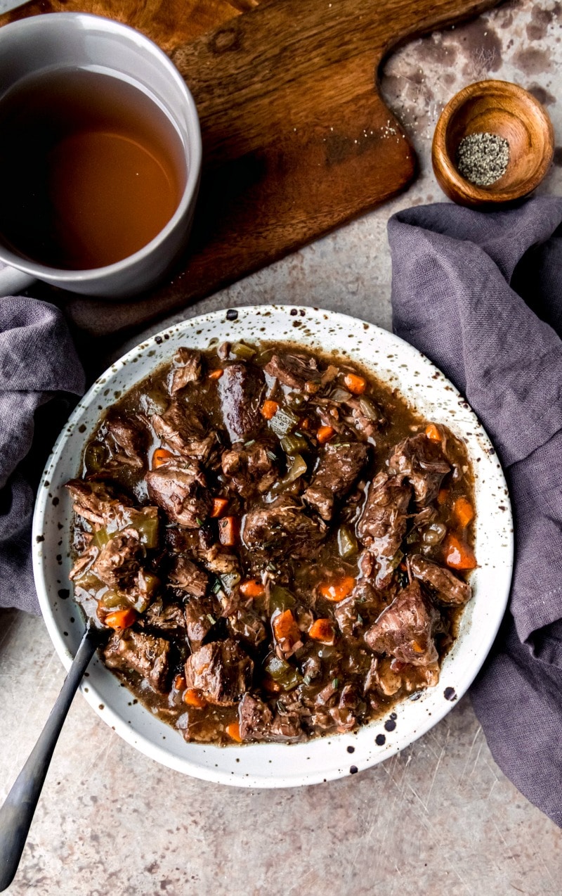 Dish of slow cooker beef bourguignon with a black spoon in it