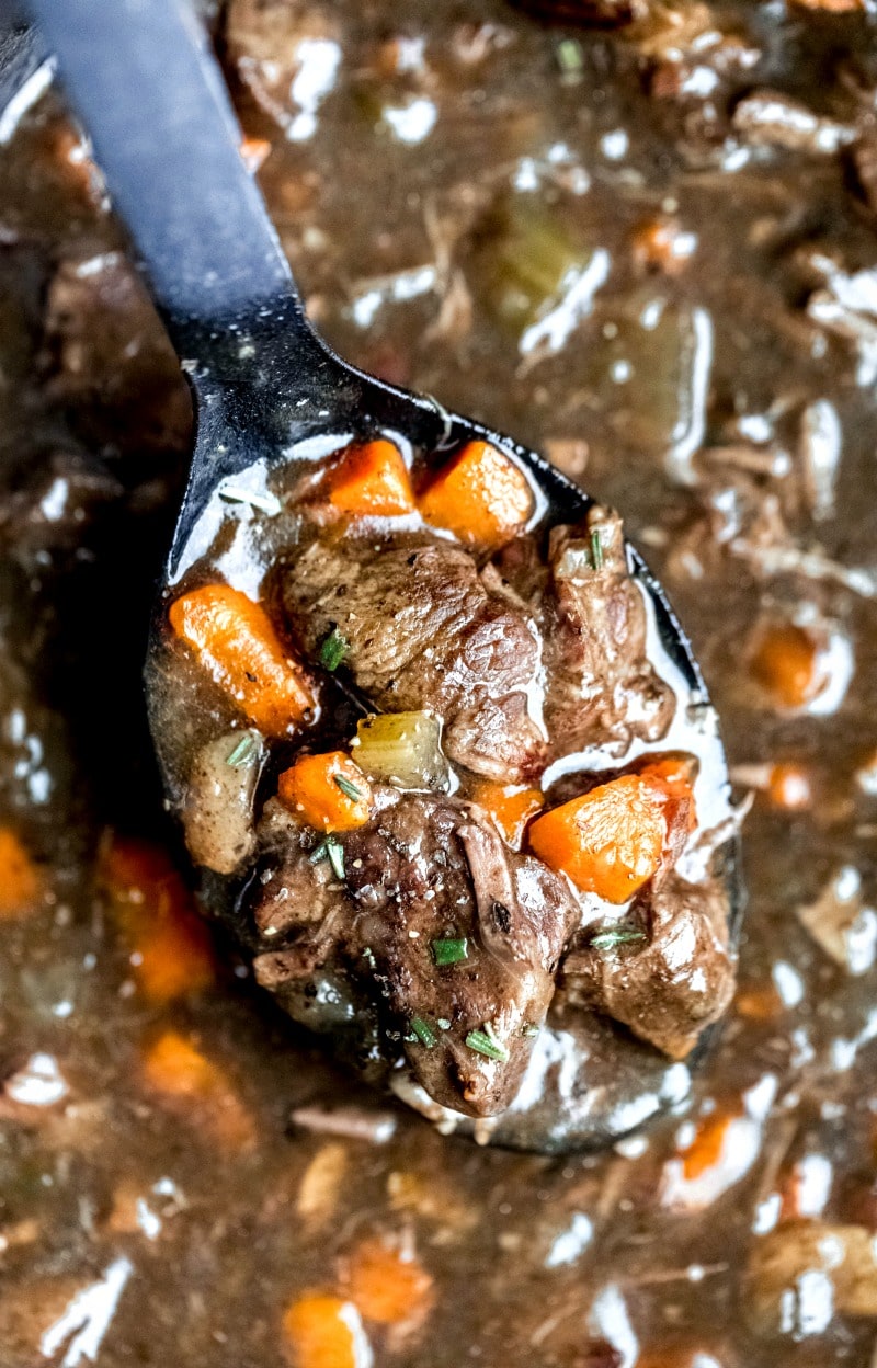 Black spoon with a scoop of slow cooker beef bourguignon