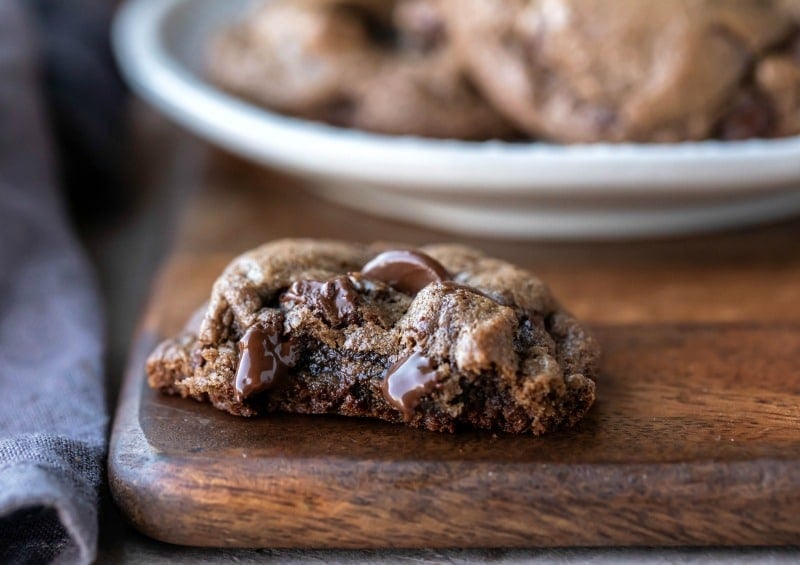 Half of a chocolate mint cookie on a wooden cutting board