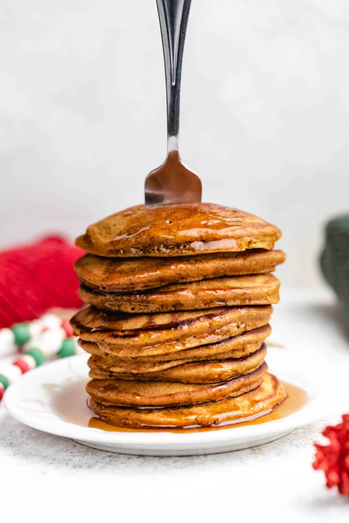 A stack of gingerbread pancakes with a fork sticking out of it. 