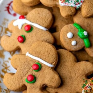 Christmas plate stacked with cut out gingerbread men cookies