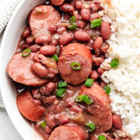 Slow cooker red beans and rice in a bowl topped with sliced green onion.