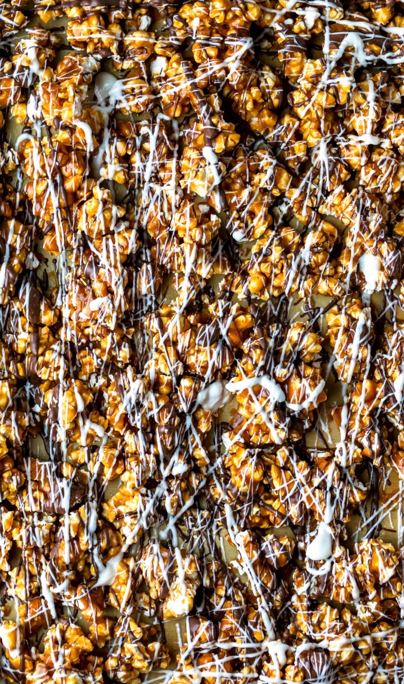 Zebra popcorn drizzled with white chocolate and milk chocolate on a silicone baking liner