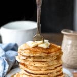 Stack of multigrain pancakes with a fork sticking out of them