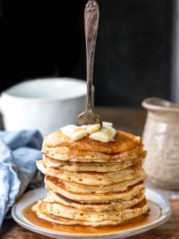 Stack of multigrain pancakes with a fork sticking out of them