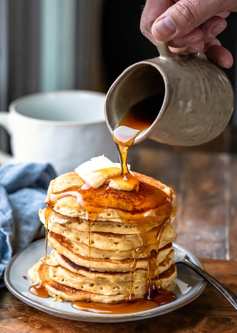 Stack of multigrain pancakes with butter and syrup on top