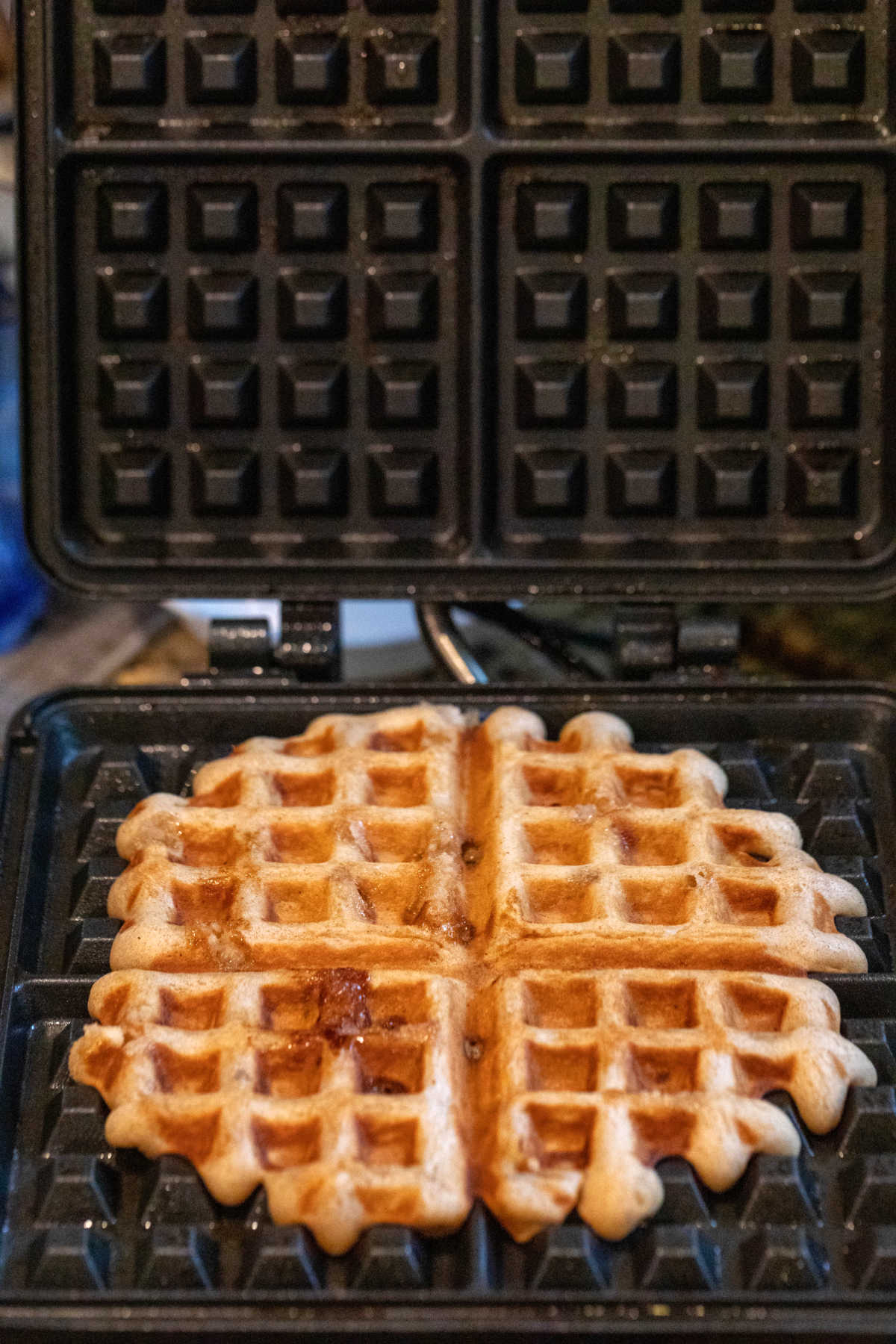 Banana bread waffle cooking in a waffle iron.