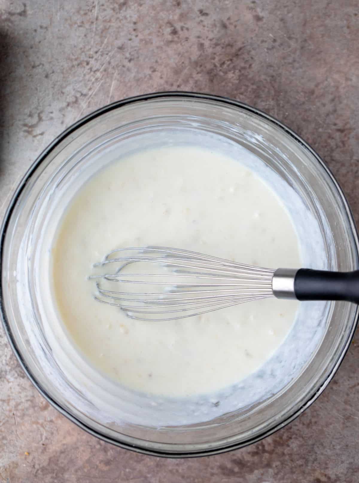 Wet ingredients for banana waffles in a bowl. 