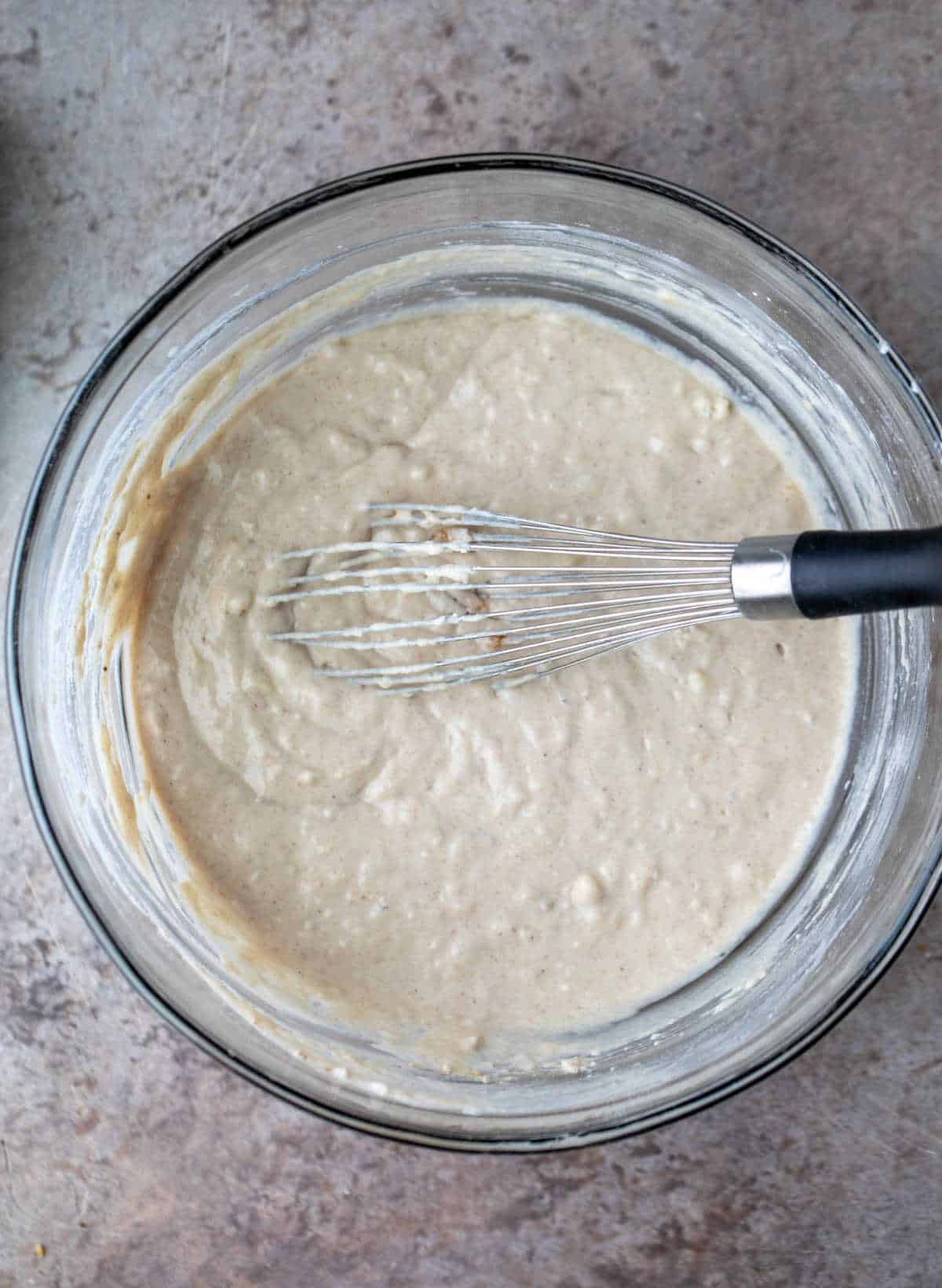 Banana waffle batter in a glass mixing bowl. 