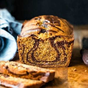 Loaf of marble banana bread next to a blue linen napkin