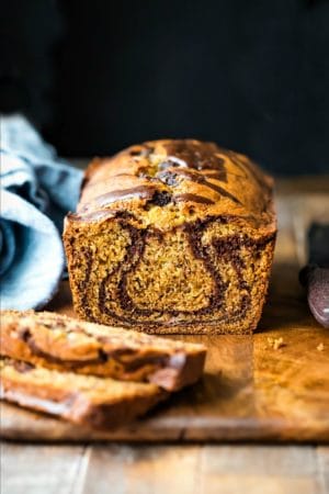 Loaf of marble banana bread next to a blue linen napkin